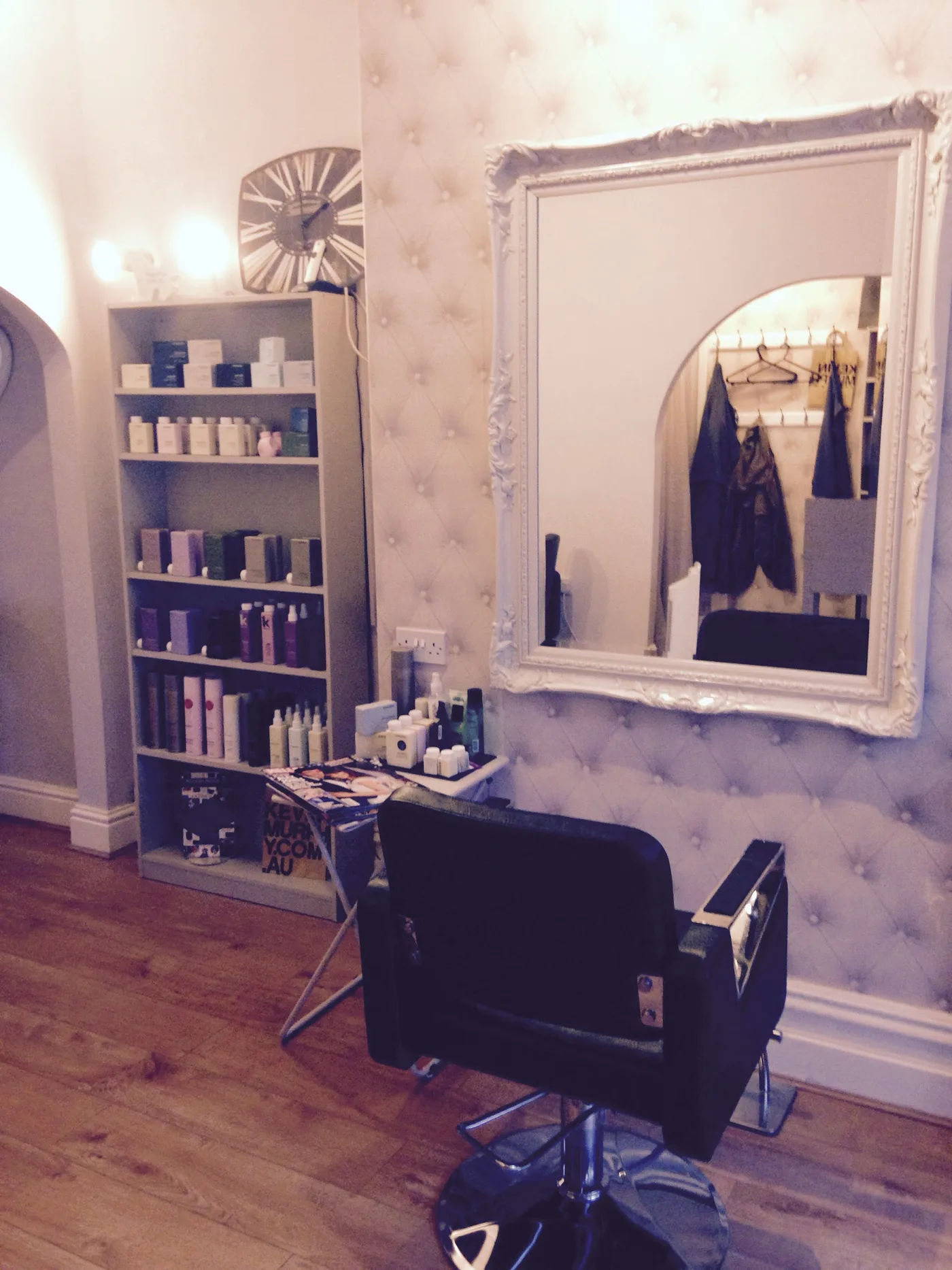 A styling chair beneath an ornate mirror at Afouro